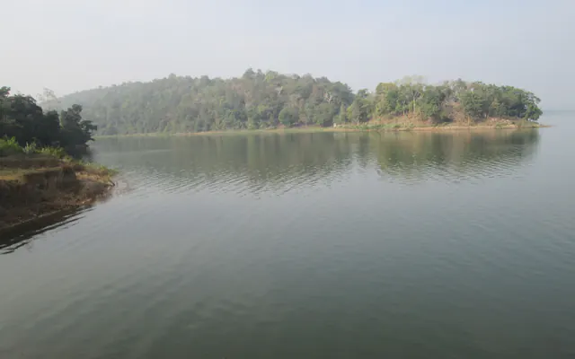 Still water of the Kinnerasani reservoir with a forested island, Bhadradri Kothagudem district, Telangana.